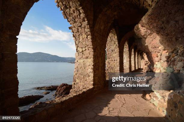 arches and public path under chateau de la napoule mandelieu-la-napoule - darmschleimhaut stock-fotos und bilder