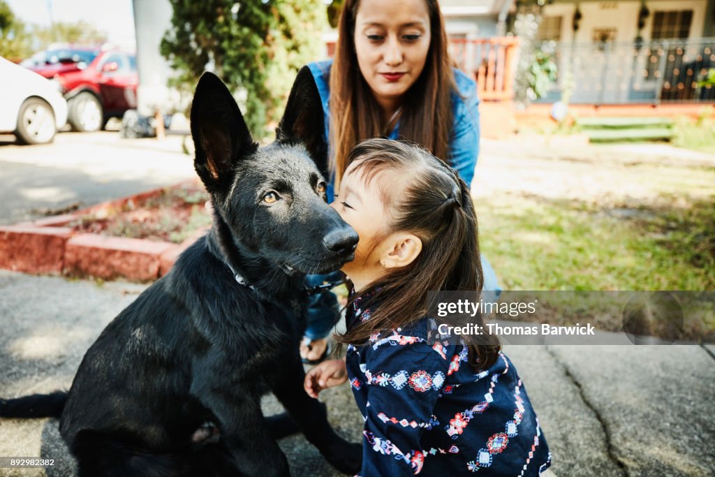 Young girl giving her dog a kiss