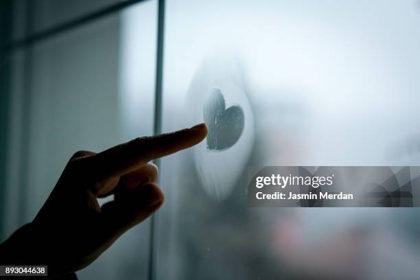 hand drawing heart on winter window glass - hot wife stockfoto's en -beelden