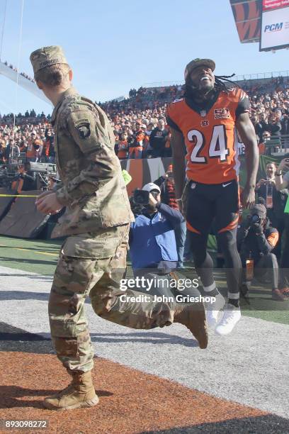 Adam Jones of the Cncinnati Bengals takes the field with a member of the U.S. Armed Forces before the game against the Cleveland Browns at Paul Brown...