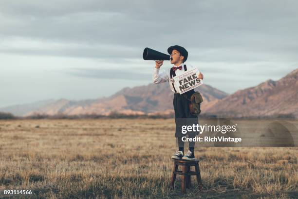 notícias menino segurando o jornal falso à moda antiga - press release - fotografias e filmes do acervo