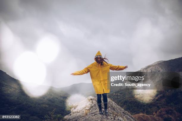 seul le montagne de fille randonnée - vêtement de pluie photos et images de collection