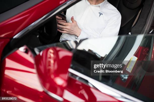 An employee sits in the driver seat of a Tesla Inc. Model S P100D sedan vehicle at the company's new showroom in New York, U.S., on Thursday, Dec....