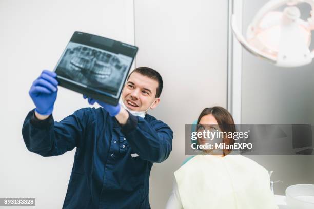 dentist showing x-ray to a patient - dental imaging stock pictures, royalty-free photos & images