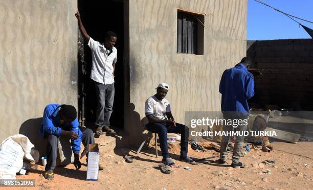 African migrants sit in the sun at a Safe House in the town of Bani Walid, on the edge of the desert 170 kilometres southeast of the Libyan capital...