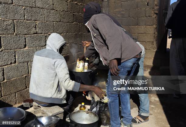 African migrants prepare food at a Safe House in the town of Bani Walid, on the edge of the desert 170 kilometres southeast of the Libyan capital...