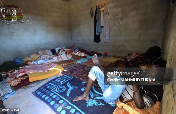 An African migrant looks towards the camera as he sits in a room at a Safe House in the town of Bani Walid, on the edge of the desert 170 kilometres...