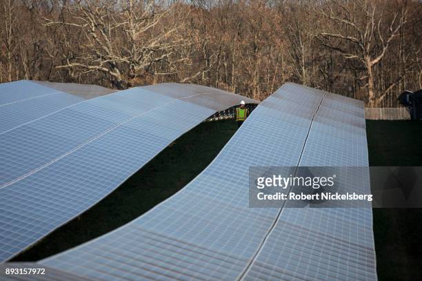 Employees from a Radian Generation's operations and maintenance team change out a faulty solar inverter along a row of solar panels December 4, 2017...