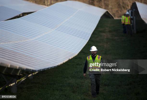 Employees from a Radian Generation's operations and maintenance team change out a faulty solar inverter along a row of solar panels December 4, 2017...