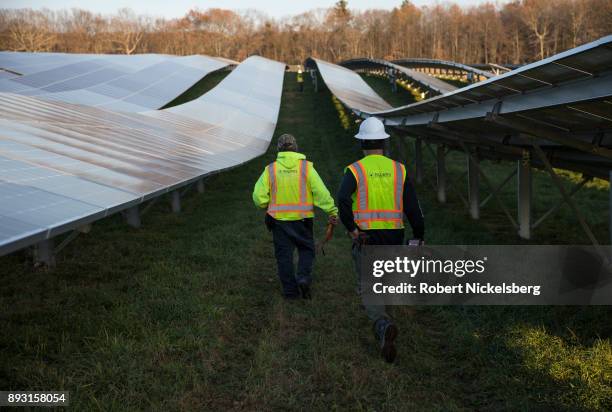 Employees from a Radian Generation's operations and maintenance team change out a faulty solar inverter along a row of solar panels December 4, 2017...