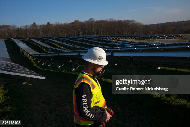 Employees from a Radian Generation's operations and maintenance team change out a faulty solar inverter along a row of solar panels December 4, 2017...