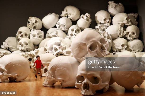 Three year old Josh Bedford runs through artist Ron Mueck's world-premiere installation 'Mass', consisting of 100 larger-than-life skulls each...