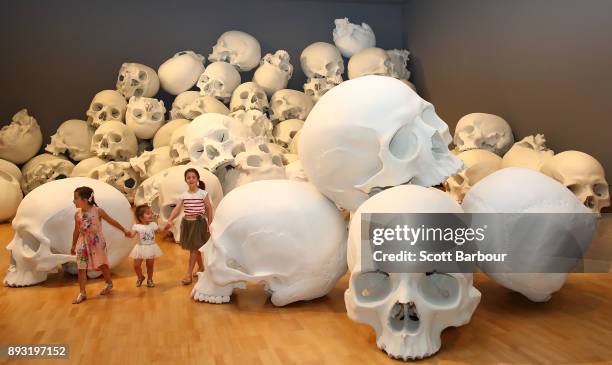 Children walk through artist Ron Mueck's world-premiere installation 'Mass', consisting of 100 larger-than-life skulls each measuring 1.5m x 2m...