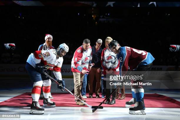Command Sergeant Major Joseph W. Bishop drops the ceremonial puck next to his wife, Kay, two sons Lance, and Sergeant First Class Joseph Bishop Jr,...