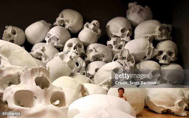 Child walks through artist Ron Mueck's world-premiere installation 'Mass', consisting of 100 larger-than-life skulls each measuring 1.5m x 2m during...