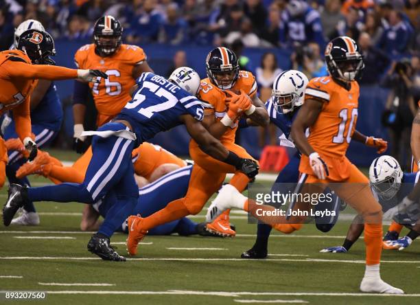 Denver Broncos running back Devontae Booker picks up a few yards as he is brought down by Indianapolis Colts inside linebacker Jon Bostic during the...