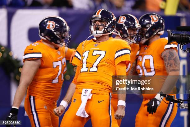 Brock Osweiler of the Denver Broncos celebrates with teammates after a touchdown against the Indianapolis Colts during the second half at Lucas Oil...