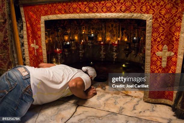 sikh man kissing jesus' birthplace in bethlehem, palestine - pilgrimage stock pictures, royalty-free photos & images