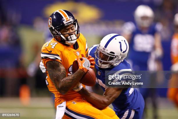 Cody Latimer of the Denver Broncos makes a catch as he is tackled by D.J. White of the Indianapolis Colts during the second half at Lucas Oil Stadium...