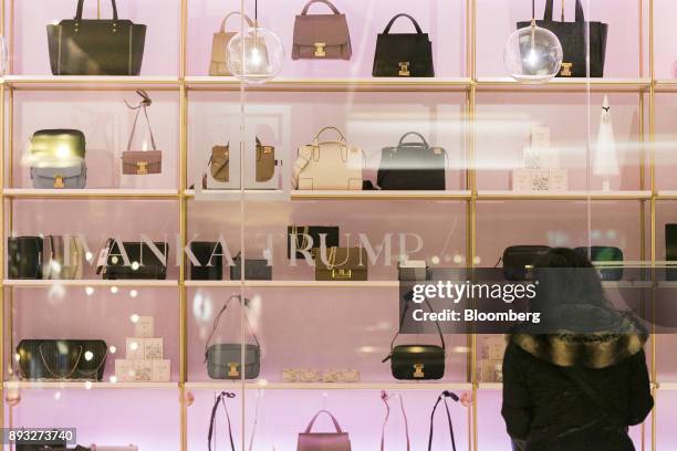 Pedestrian looks at handbags on display from outside an Ivanka Trump brand store at Trump Tower in New York, U.S., on Thursday, Dec. 14, 2017....