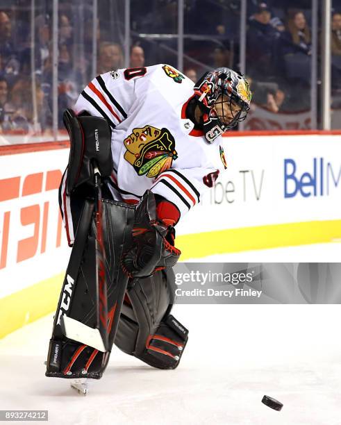 Goaltender Corey Crawford of the Chicago Blackhawks shoots the puck around the boards during second period action against the Winnipeg Jets at the...