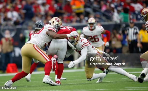 Reuben Foster and DeForest Buckner of the San Francisco 49ers tackle Lamar Miller of the Houston Texans during the game at NRG Stadium on December...