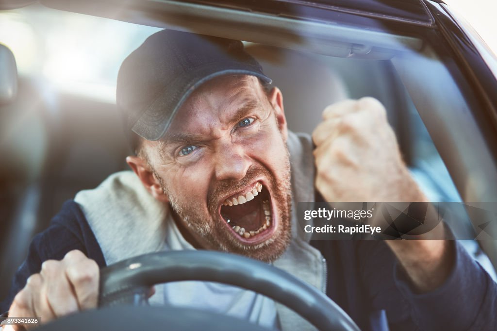 Enraged man shaking fist through windscreen: road rage