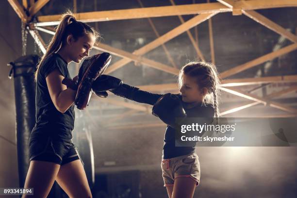 meisje beoefenen van boksen met haar coach in healthclub. - woman gym boxing stockfoto's en -beelden