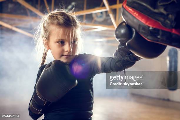 small boxer exercising punches on a sports training in a gym. - martial arts stock pictures, royalty-free photos & images