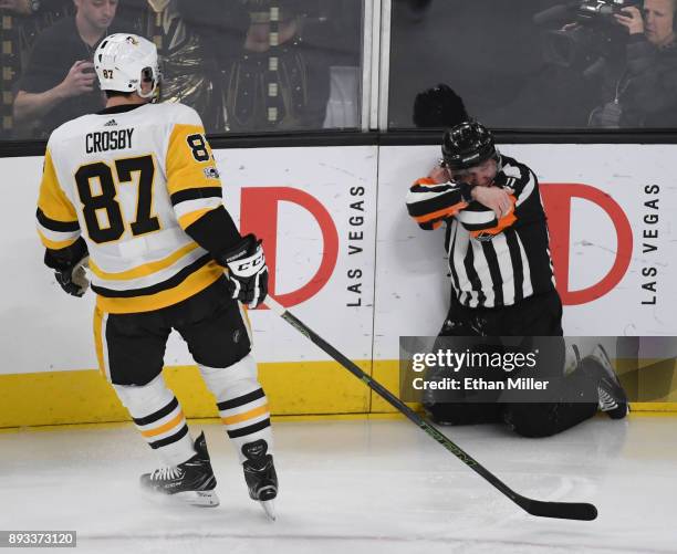 Sidney Crosby of the Pittsburgh Penguins checks on referee Kelly Sutherland after he was hit with a puck in the second period of a game between the...