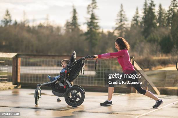 mom goes jogging with infant in stroller - compound bow stock pictures, royalty-free photos & images