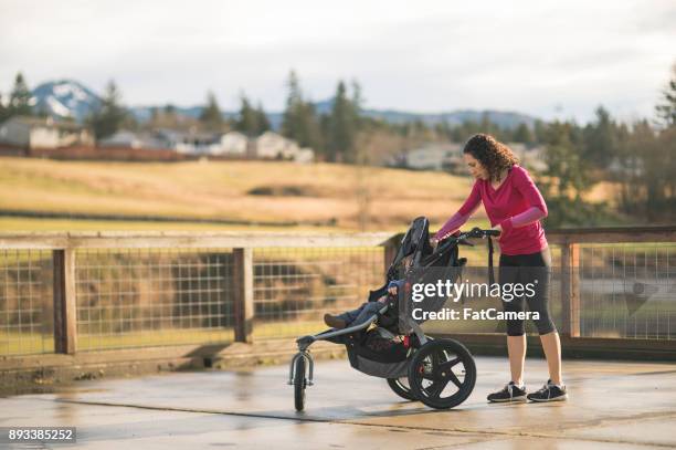 mom goes jogging with infant in stroller - compound bow stock pictures, royalty-free photos & images
