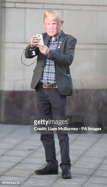 Britain First supporter Andrew Edge, wearing a Donald Trump mask, takes a selfie outside Belfast Laganside courts, where the deputy leader of the...