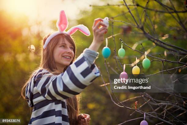 mädchen, verkleidet als osterhase ostereier hängend - bunny eggs stock-fotos und bilder