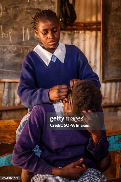 Student fix her friend's haircut. Ngota's Upendo Primary School is a small school located in the heart of Mathare Slum, Kenya's second biggest slum...