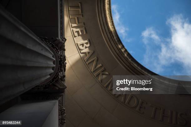 The words "The Bank" sit in masonry lettering on the roof of a public walkway at the Bank of England in the City of London, U.K., on Friday, Dec. 15,...