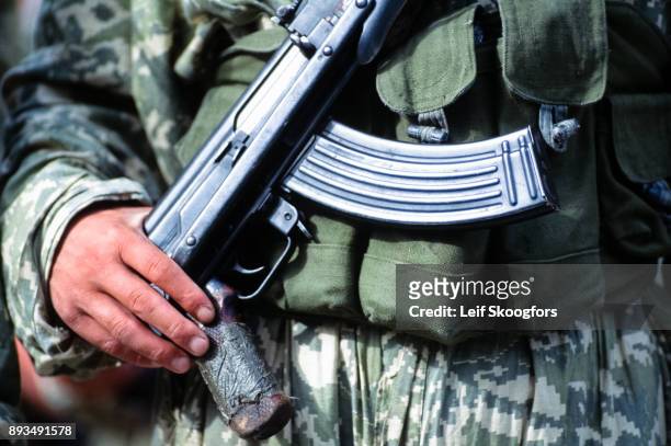 Close-up of the hands of an unidentified Albanian soldier in camouflage white a Chinese-made, AK-47 assault rifle, Durres, Albania, 1995. The photo...