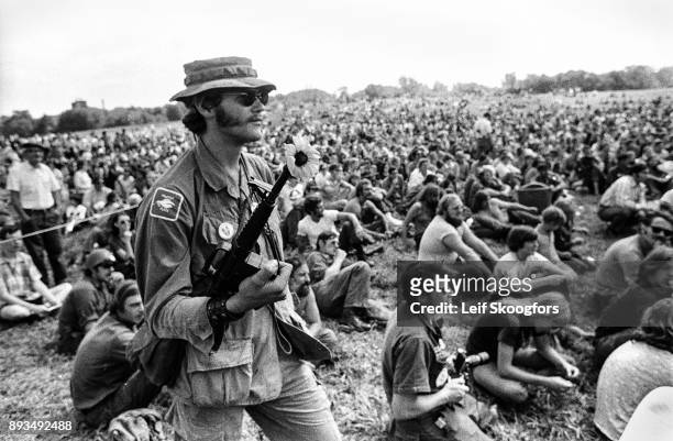 View of an unidentified veteran with a toy M-16 rifle and flower as he attends the Vietnam Veterans Against the War 'Operation RAW rally in Valley...