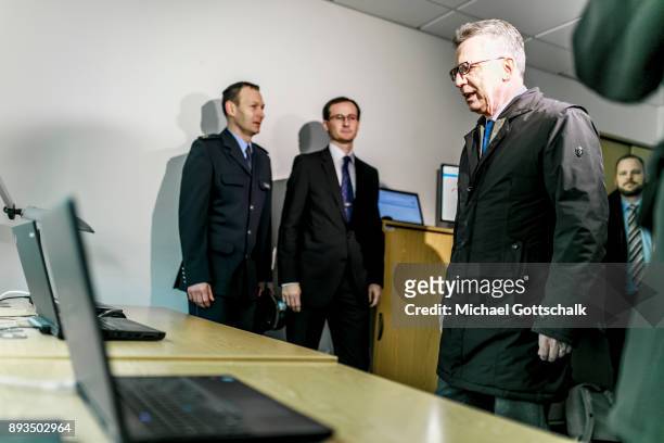 German Interior Minister Thomas de Maiziere inspects three computers with different monitoring systems during his visit to a project for automatic...
