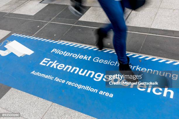 Passerby crosses signs which indicate the area for automatic recognition of faces at trainstation Suedkreuz on December 15, 2017 in Berlin, Germany.