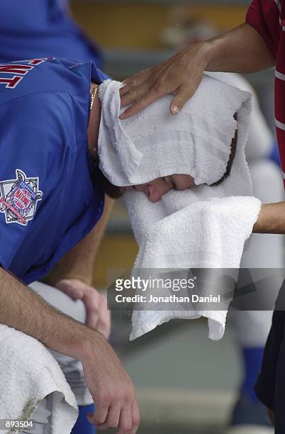 Starting pitcher Matt Clement of the Chicago Cubs gets a cold, wet towel wrapped around his head in the dugout by a trainer during a game against the...