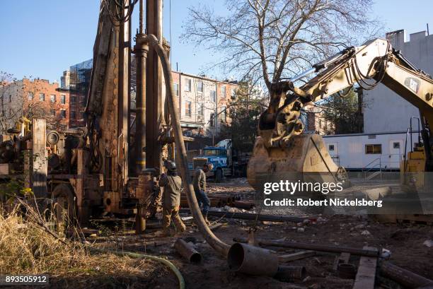 Construction workers bore into the ground to place pilings for a 15-story residential building December 7, 2017 in Brooklyn, New York. The land was...