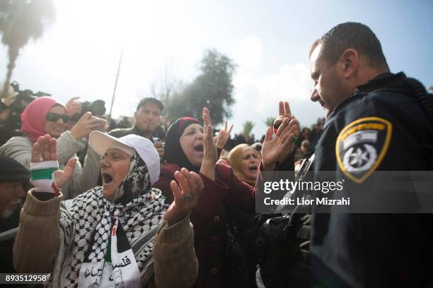 Palestinian women protest next to an Israeli police officer after Friday prayers outside the Old City on December 15, 2017 in Jerusalem, Israel....