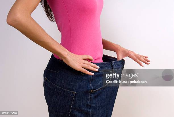 woman wearing large jeans, diet - mass unit of measurement stock pictures, royalty-free photos & images