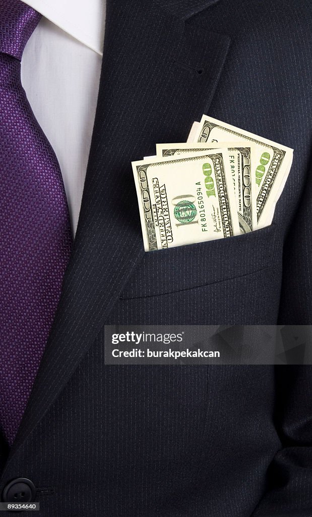 Businessman with dollars in his jacket pocket