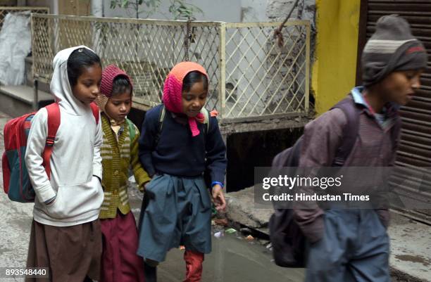 School Students cover themselves with woolen clothes on a cold winter morning, on December 15, 2017 in New Delhi, India. Expect a further dip in...