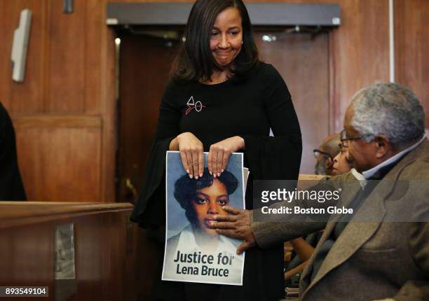 Eva Mitchell carries a photo of Lena Bruce as she arrives for the sentencing of James Witkowski at Suffolk Superior Court in Boston on Dec. 14, 2017....