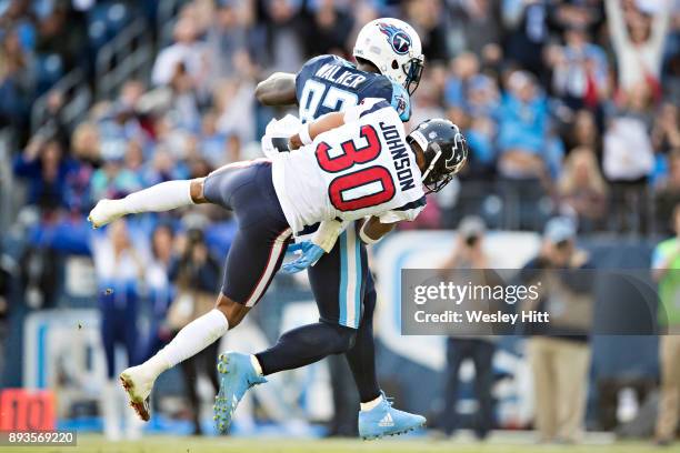 Delanie Walker of the Tennessee Titans catches a pass and runs the ball for a touchdown while being tackled by Kevin Johnson of the Houston Texans at...