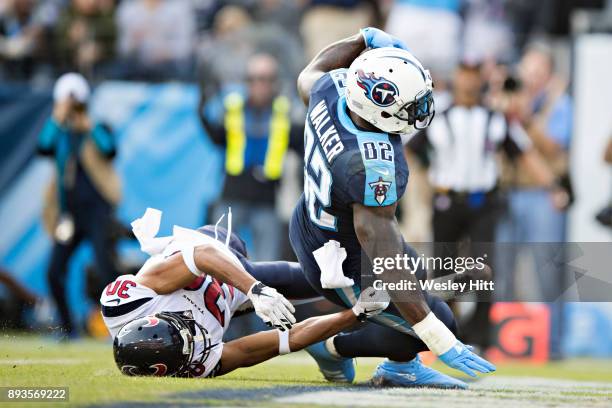Delanie Walker of the Tennessee Titans catches a pass and runs the ball for a touchdown while being tackled by Kevin Johnson of the Houston Texans at...