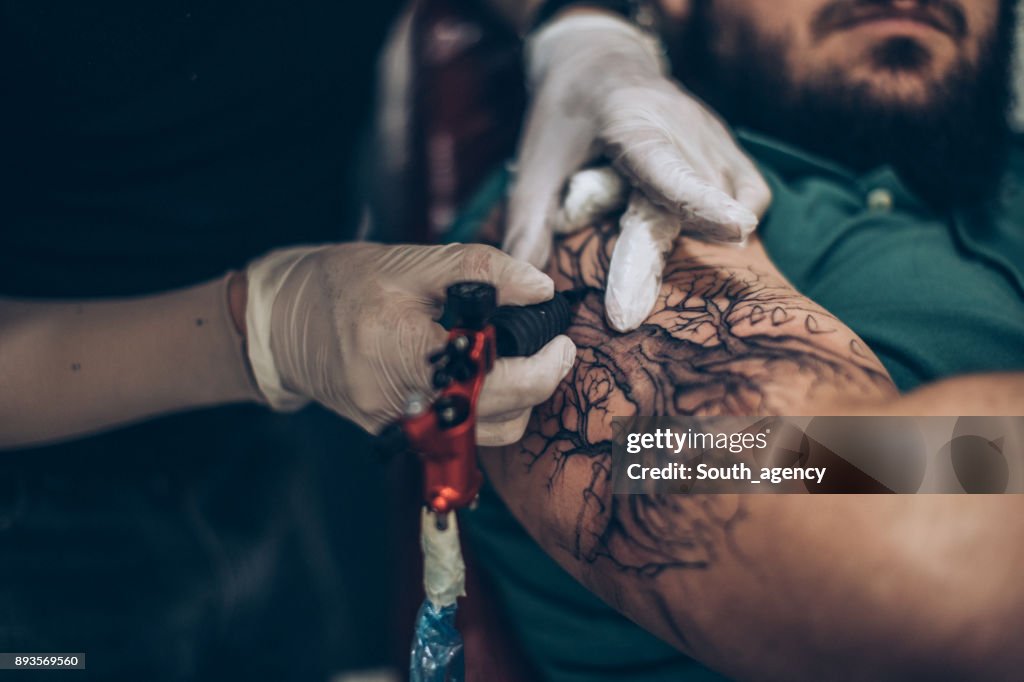 Manos de artista del tatuaje